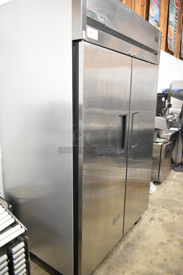 2022 True TG2R-2S-HC stainless steel commercial 2-door reach-in cooler with poly-coated racks and casters. Model visible.