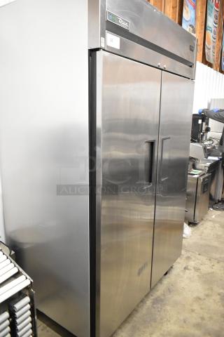 2022 True TG2R-2S-HC stainless steel commercial 2-door reach-in cooler with poly-coated racks and casters. Model visible.