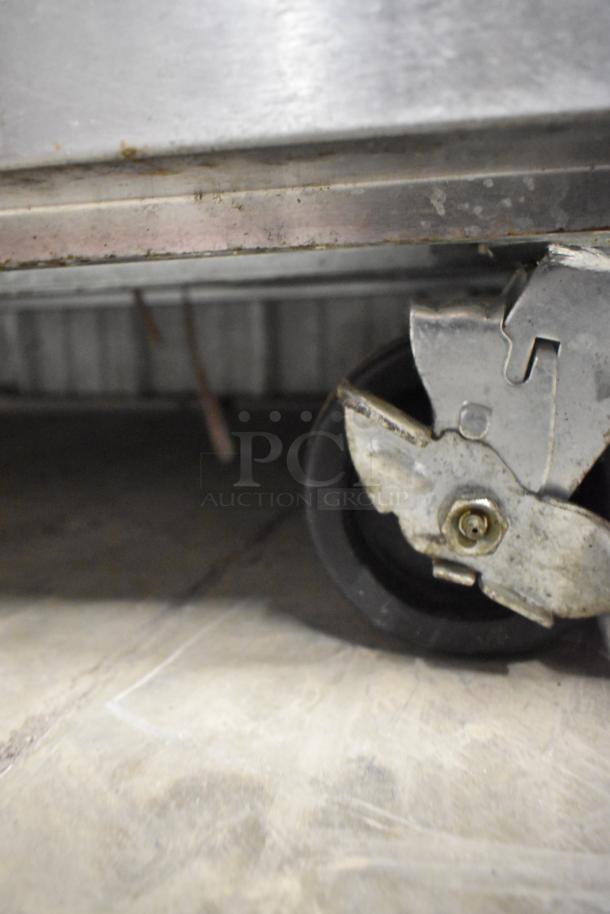 Close-up of a commercial caster wheel from a Beverage Air HBR49HC-1-HG stainless steel cooler, showing moderate wear.