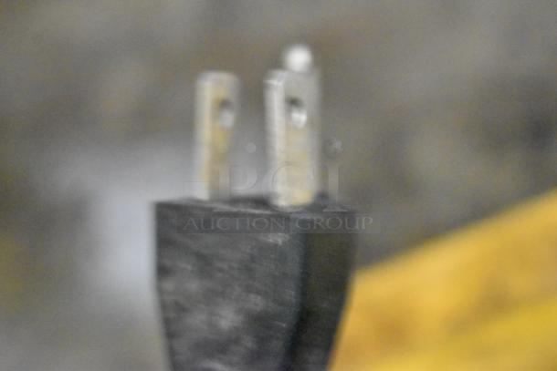 Out of focus close-up of a power plug, likely related to a DeWalt DXH50K kerosene heater.