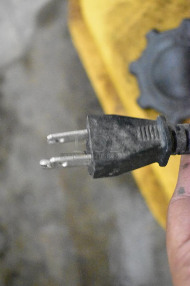 Close-up of a DeWalt DXH50K kerosene heater plug, showing standard two-prong design. Surface appears slightly worn.