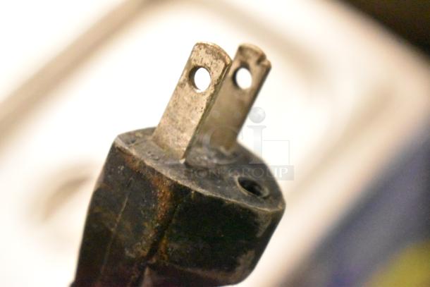 Close-up of a worn metal power plug for a 120V, 1-phase countertop food warmer, showing signs of use.