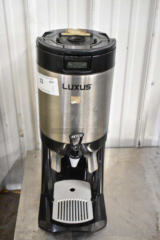 Fetco L4S-15 Luxus Beverage Dispenser, stainless steel, visible brand markings, digital display, auction label attached.