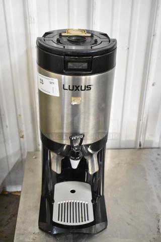 Fetco L4S-15 Luxus Beverage Dispenser, stainless steel, visible brand markings, digital display, auction label attached.