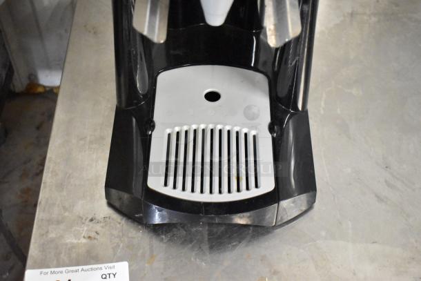 Fetco L4S-15 Luxus Beverage Holder Dispenser, black and silver, shows spout and drip tray, good condition.