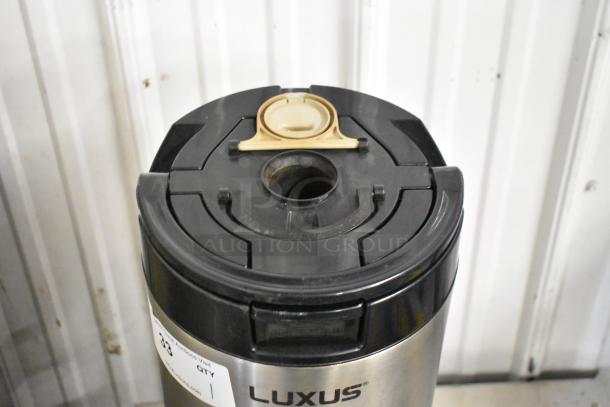 Fetco L4S-15 Luxus Beverage Holder Dispenser, stainless steel, black lid, luxury design, visible label.