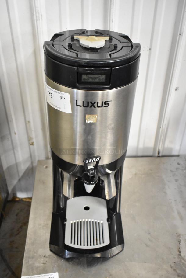 Fetco L4S-15 Luxus Beverage Dispenser, stainless steel, black trim, visible brand logos, good condition.