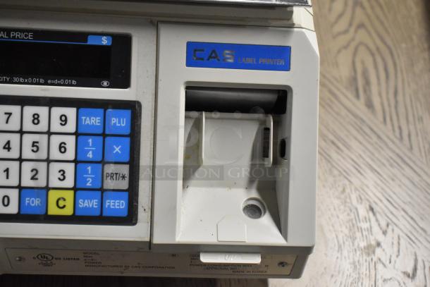CAS LP-1000 metal countertop scale with label printer. Features numeric keypad, 120 volts, 1 phase. Slight wear visible.
