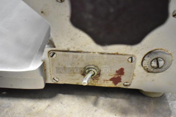 Globe stainless steel commercial countertop meat slicer, visible wear, included sharpening blade, 115 volts, 1 phase.