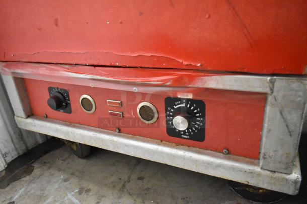 Cres-Cor Crown-X H-137-UA-12 heated holding cabinet in red with control dials and commercial casters, 115V, 1 phase.