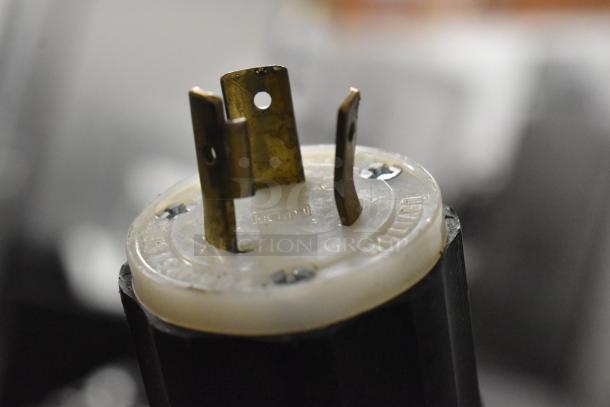 Close-up of a plug from a Cres-Cor Crown-X H-137-UA-12 heated holding cabinet, showing metal prongs and markings.