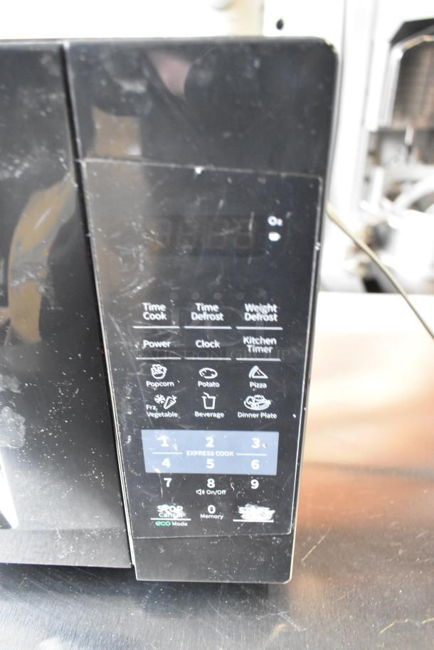2020 Comfee EM720CPL-PMB microwave oven, digital control panel, 120V, black, minor surface wear visible.