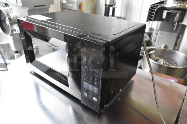 2020 Comfee EM720CPL-PMB countertop microwave, black, touchpad controls, good condition, 120 volts, model label visible.