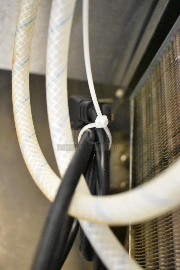 Close-up of cables and a zip tie inside the Delfield Welbilt ND21RS00B stainless steel undercounter cooler.