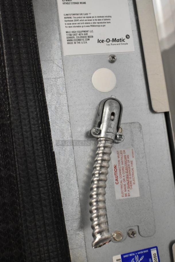 2024 Ice-O-Matic CIM1446HA6 commercial ice head, stainless steel, featured on ice bin. Labels indicate warnings and manufacturing details.