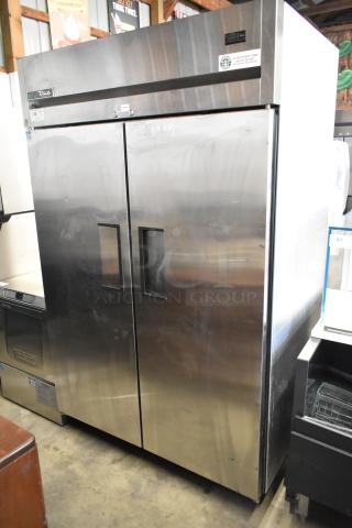 True TG2R-2S-HC stainless steel commercial 2-door reach-in cooler with poly-coated racks on casters. 115V, 1 phase.