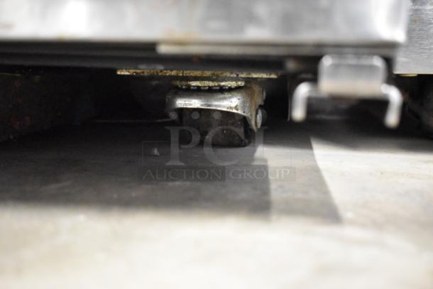 2023 True TUC-27-HC undercounter cooler on commercial casters, showing detail of sturdy caster wheel mechanism.