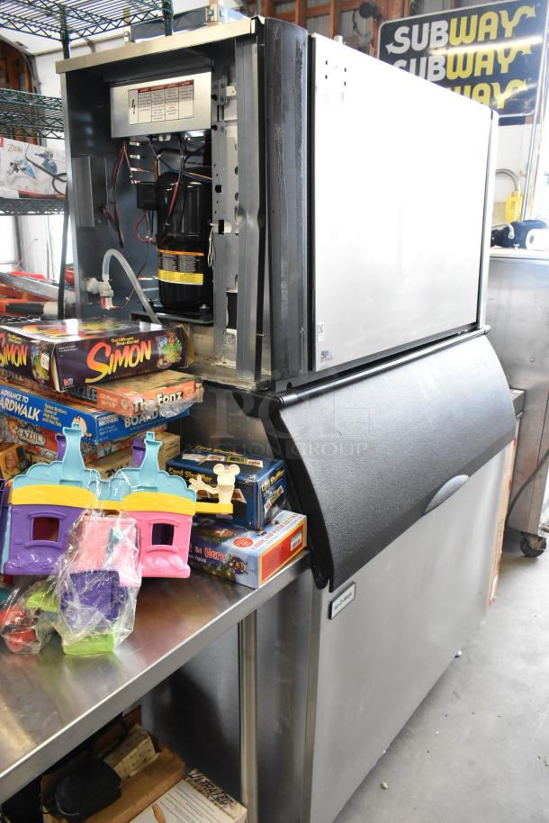 2023 Ice-O-Matic CIM1446HR6 stainless steel commercial ice head on bin. Voltage 208-230, 1 phase. Model tag visible.