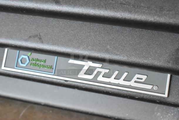 True GDM-12-HC cooler with "natural refrigerant" label shown. New condition, 115V, single door, poly-coated racks.