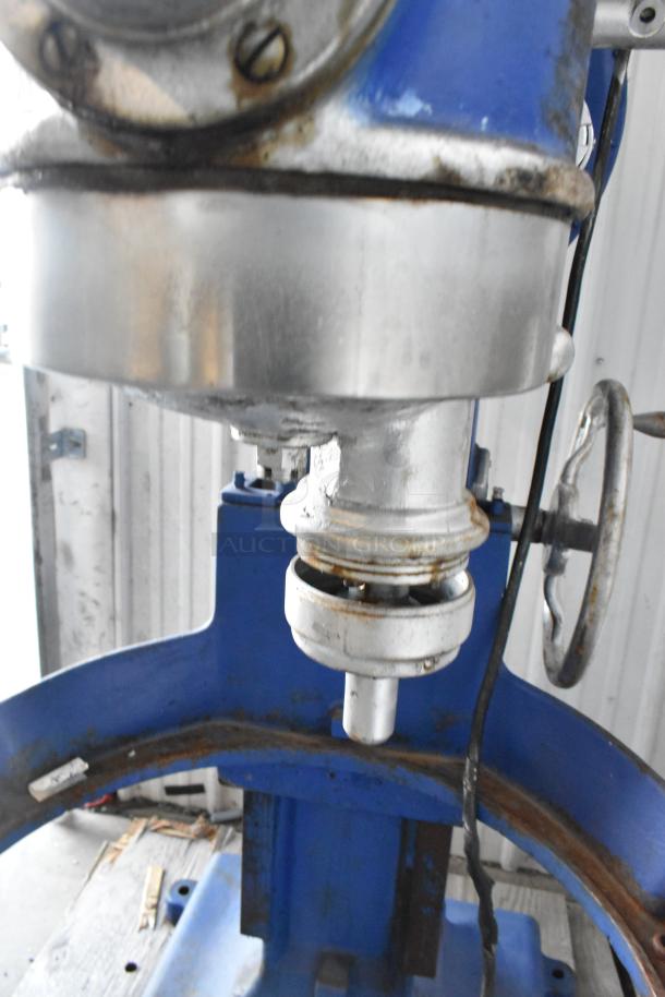 Metal commercial planetary dough mixer, floor style, with visible wear, blue and silver finish, crank handle shown.