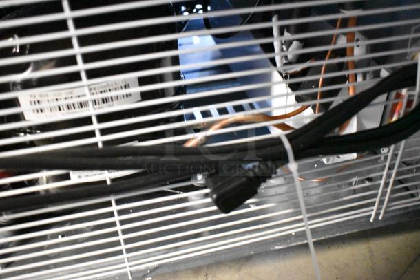 Alt text: Close-up of the back of a KoolMore KM-MDR-1GD-10C cooler showing wiring and labels inside, with visible casters.