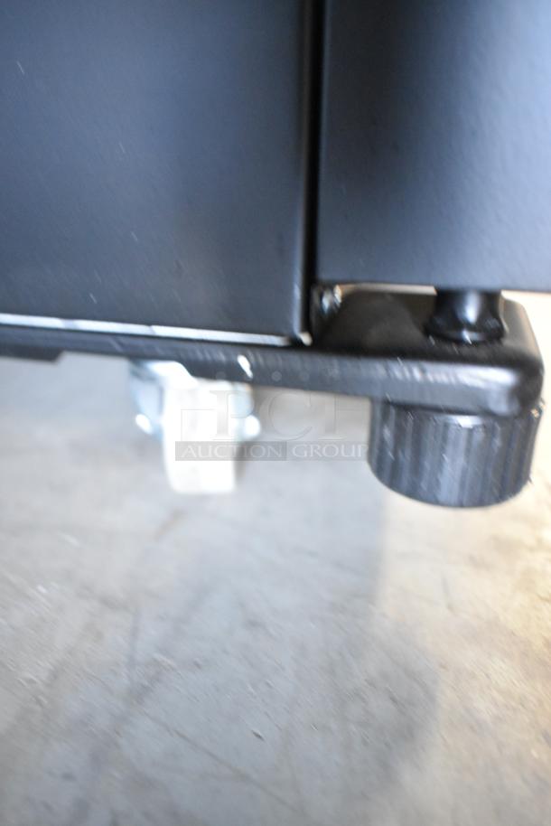 Close-up of black base and caster of KoolMore KM-MDR-1GD-10C cooler. Visible poly-coated rack, commercial caster.