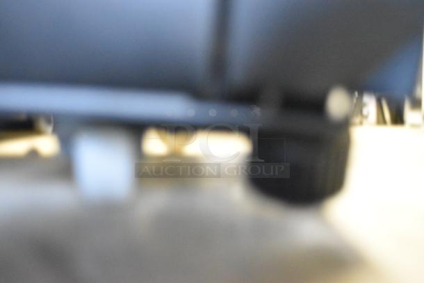 Blurry image of KoolMore KM-MDR-1GD-10C cooler's caster base. Metal commercial type with poly-coated racks. 115 Volts.