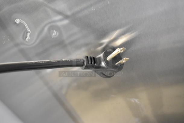 Close-up of a 115V plug for a 2021 True TSCI-600R-G-PH commercial cooler, showing metal surface reflection.