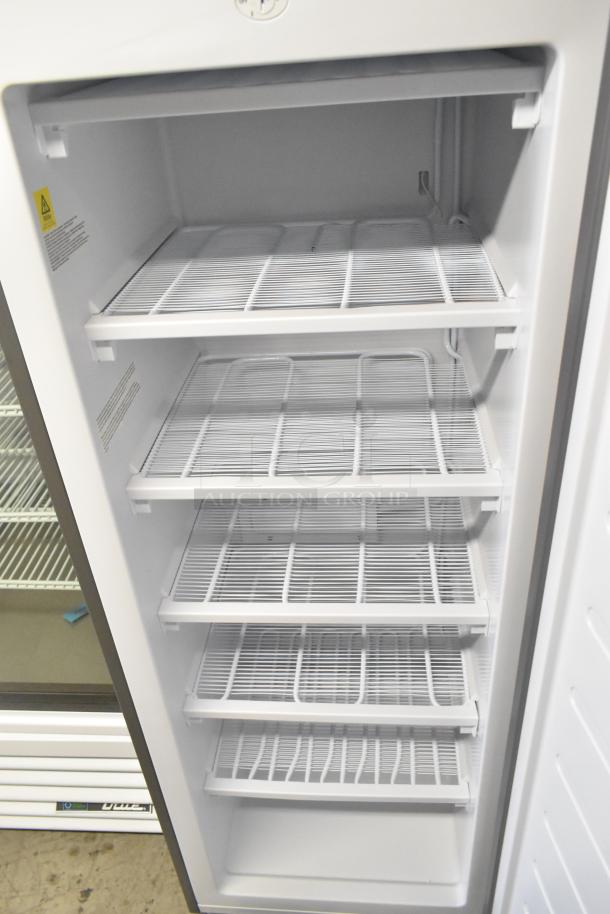 Frigidaire Gallery FGFRF699 metal upright freezer, Model FGFRF699. Single door, 115 Volts, 1 Phase, interior shelves visible.
