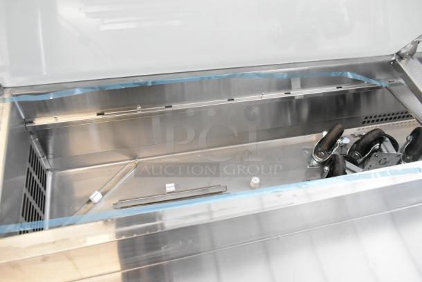 Brand new 2025 Avantco 178SSPPT3 stainless steel pizza prep table, 115V, 1 Phase. Scratch and dent item, unpacked interior view showing storage space and wheels.