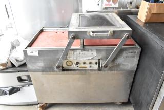 Bizerba stainless steel commercial vacuum sealer on casters, control panel with dials, industrial use, visible wear.