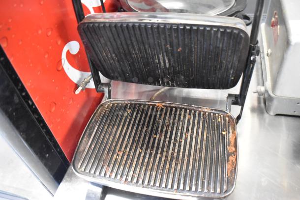 Hamilton Beach panini press with a stainless steel exterior, showing signs of wear, for auction. Includes slow cooker.