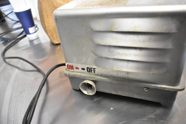Prawnto MLG-1 metal commercial shrimp deveiner, 115 volts. Visible on/off switch. Appears in used condition.