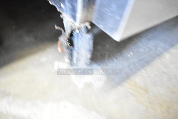 Blurry image of a commercial caster on an Atosa stainless steel chef base. Condition and drawer details not visible.