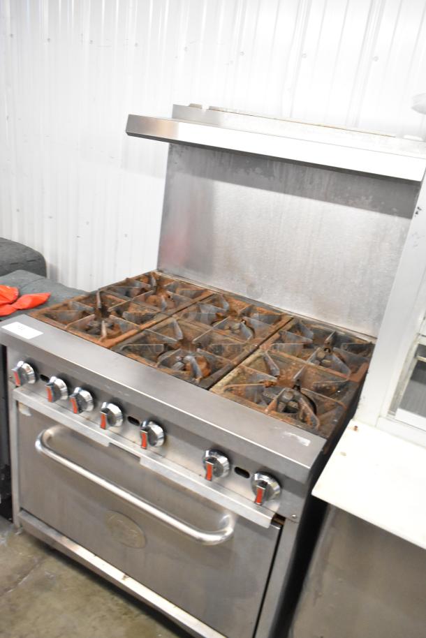Cooking Performance Group stainless steel commercial gas range with 6 burners, oven, backsplash, and overshelf; moderate wear.