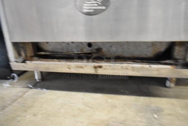 Stainless steel commercial gas range by Cooking Performance Group with 6 burners, oven, backsplash, and overshelf. Used condition.