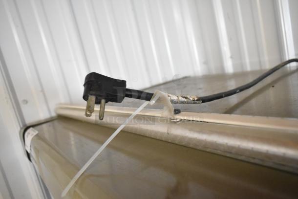 Hussmann GSVM4060 metal commercial grab-n-go merchandiser, visible power cord with slight wear, metal shelving.