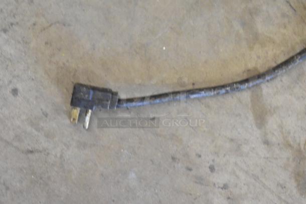 Electrical plug of the True TUC-44F stainless steel undercounter freezer, 115 volts, shown on a concrete floor.