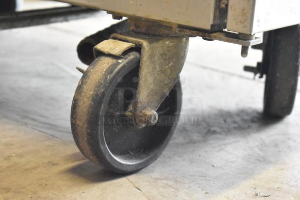 Frymaster stainless steel rethermalizer caster, showing signs of wear. Commercial-grade wheel for easy mobility.