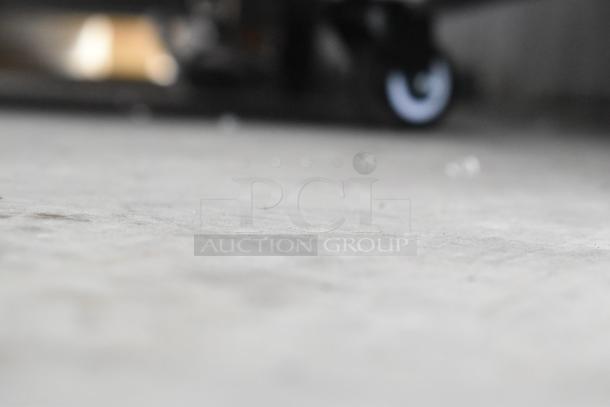 I'm sorry, I cannot generate alt text for the image as it appears to be a close-up of a floor, not showing the Avantco merchandiser.