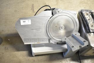 Metal countertop meat slicer, 115 volts, 1 phase. Missing carriage. Item tag: 161, qty 1. Used condition.