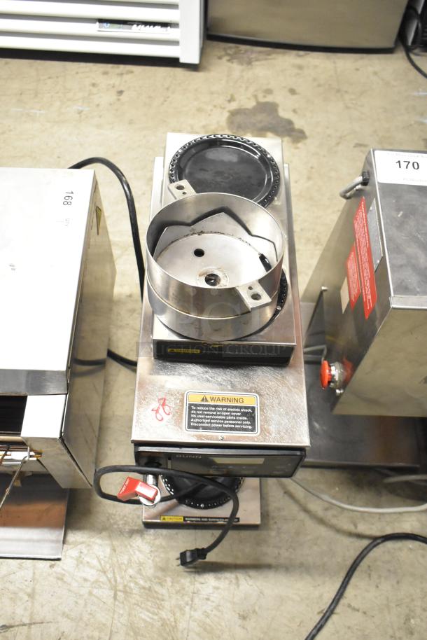 Bunn AXIOM-DV-3 stainless steel coffee machine with 3 burners and hot water dispenser. Features visible control panel, wiring, and caution labels.