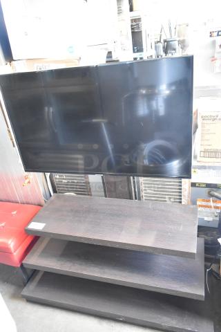 Samsung television on dark wood stand, in good condition. Includes two shelving tiers. Pickup required; no shipping.