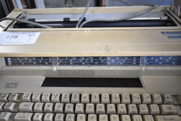 Sharp ZX-515 countertop typewriter, beige, visible wear, serial number plate, ruler guide, 115V, 1 Phase.