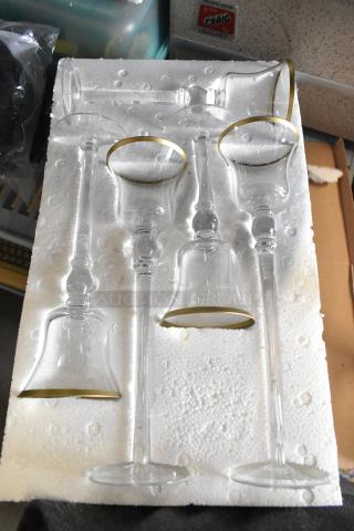 Stemmed glass votive holders with gold rims, set of five in protective foam. Excellent condition, elegant design.