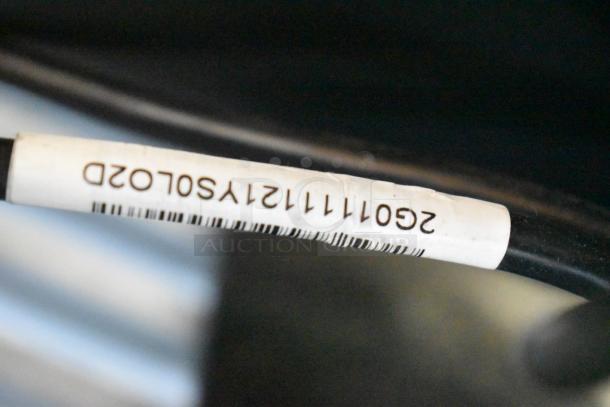 Close-up of a cable with a label showing barcode numbers: “260711121YSOLO2D.” Label for identification purposes.