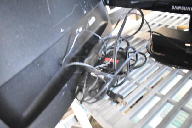 Three monitors including Asus VG249, Samsung S23C350H, and HP. Features visible cables and power cords.