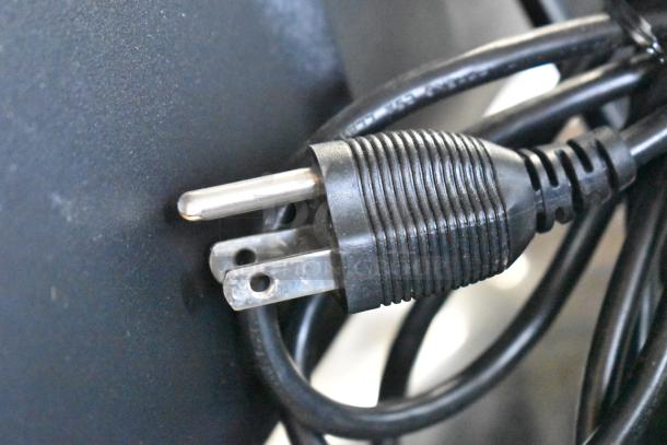 Close-up of a black electrical plug and cords, likely related to the auctioned monitors. No monitors visible.