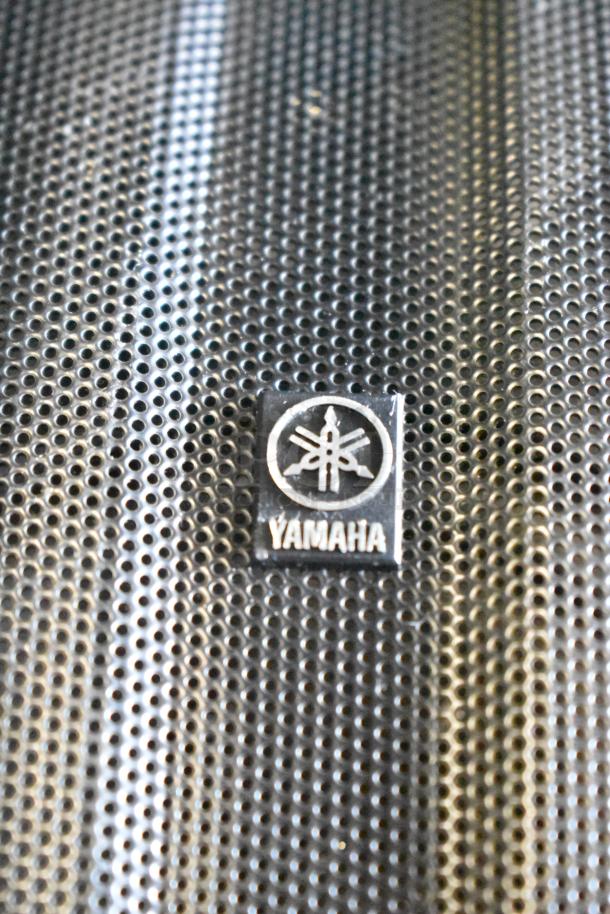 Yamaha NS-AW150 speaker grille with brand logo detail, showing perforated design.
