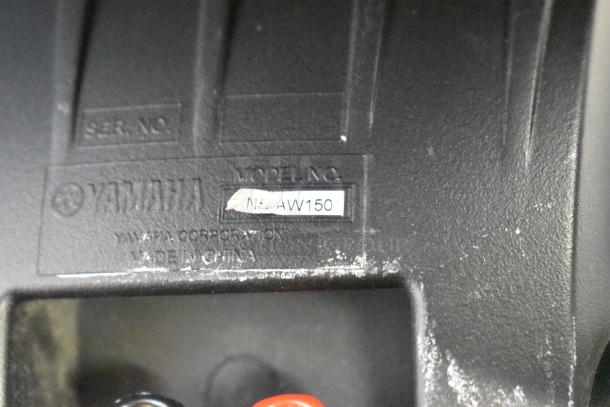 Yamaha NS-AW150 speaker label, 8 ohm, made in China. Model number visible. Slight wear on the label surface.